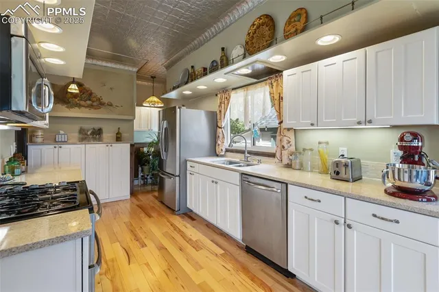 a kitchen with granite countertop a sink stainless steel appliances and cabinets