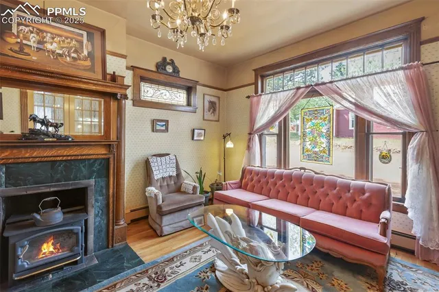 a living room with fireplace furniture and a large window