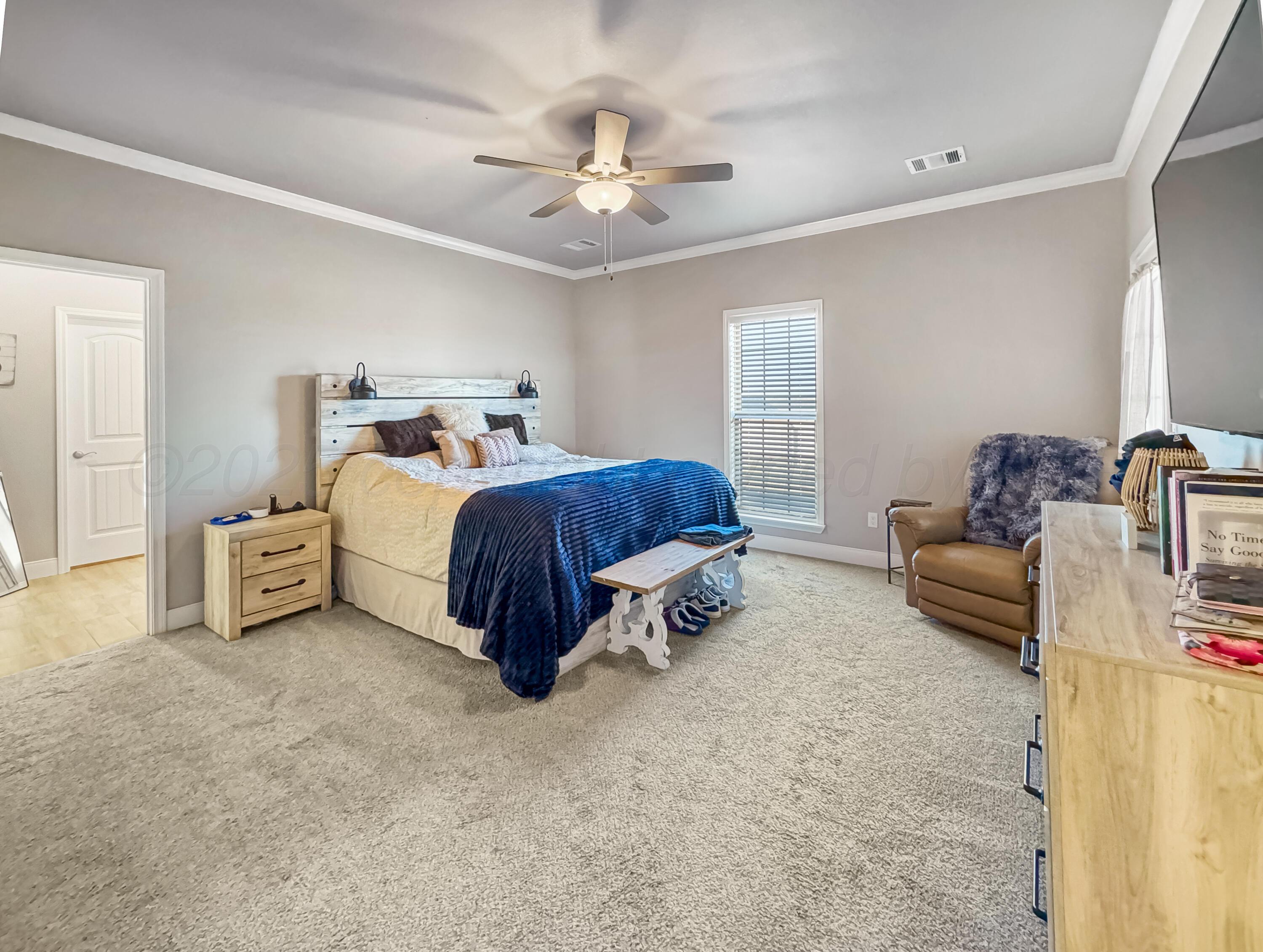 18300 Taurus Trail Canyon, TX 79015 - Photo 10 of 32 a bedroom with a bed and a chandelier