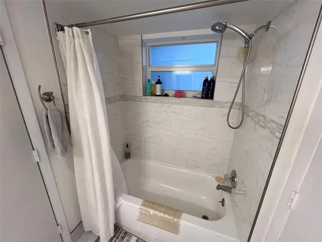 a bathroom with a tub shower vanity and a sink