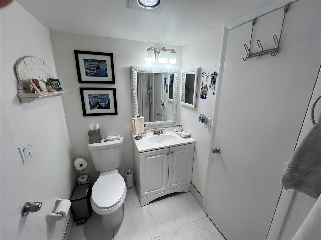9520 Seagrape Drive, Unit 103 Davie, FL 33324 - Photo 16 of 39 a bathroom with a toilet sink and mirror