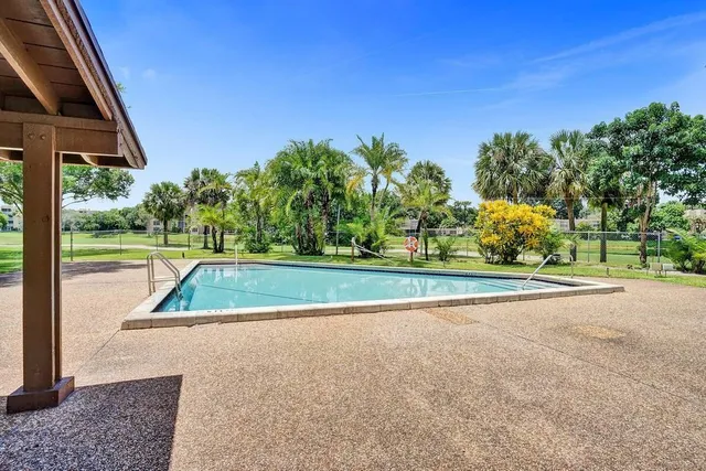 a view of swimming pool with a yard and green space