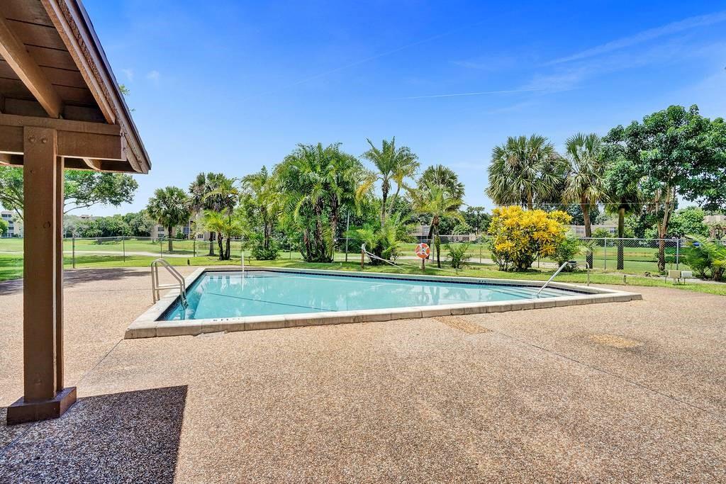9520 Seagrape Drive, Unit 103 Davie, FL 33324 - Photo 19 of 39 a view of swimming pool with a yard and green space