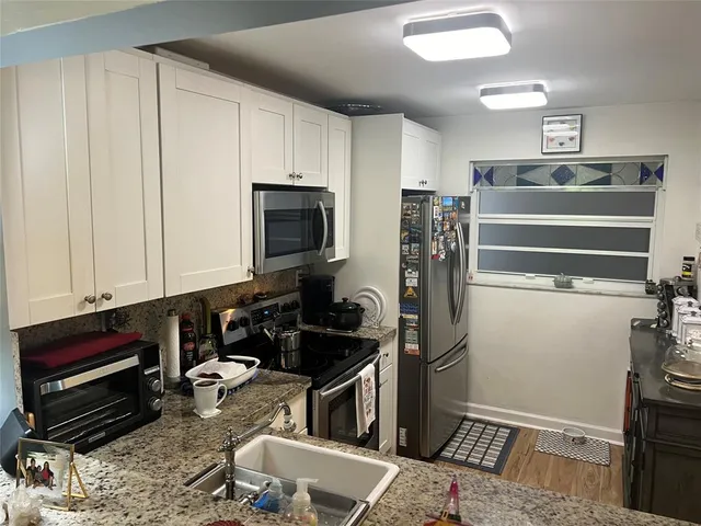 a kitchen with a refrigerator stove and cabinets