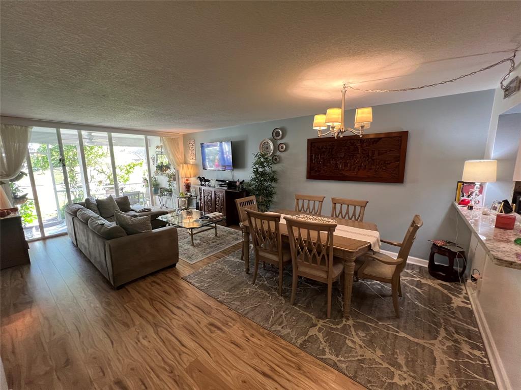9520 Seagrape Drive, Unit 103 Davie, FL 33324 - Photo 5 of 39 a living room with furniture a flat screen tv and a large window