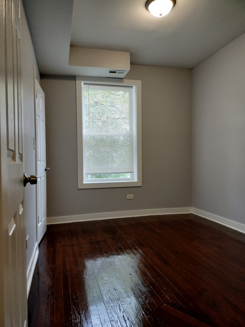 6603 South Bishop Street, Unit 66032 Chicago, IL 60636 - Photo 11 of 19 an empty room with wooden floor and windows