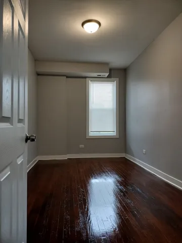 an empty room with wooden floor and a window