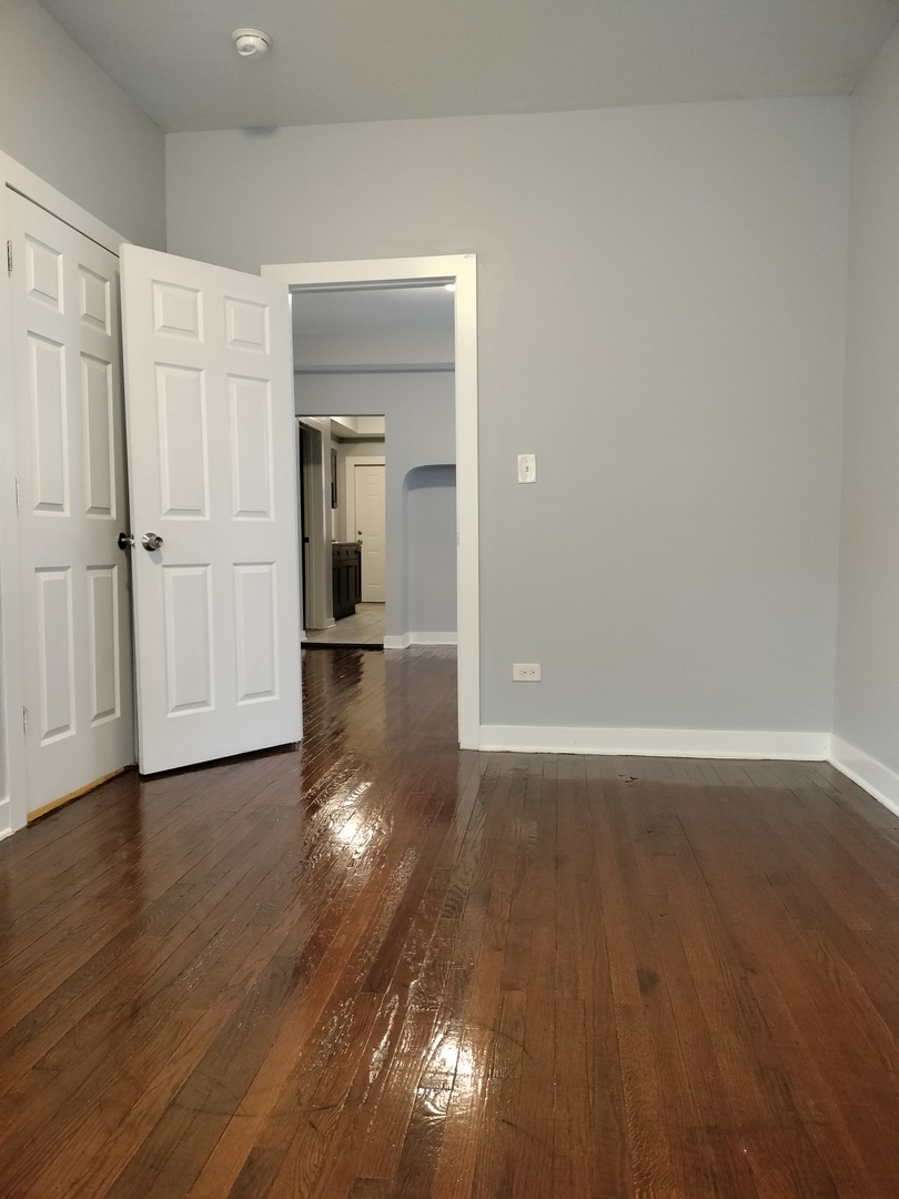 6603 South Bishop Street, Unit 66032 Chicago, IL 60636 - Photo 17 of 19 an empty room with wooden floor and windows