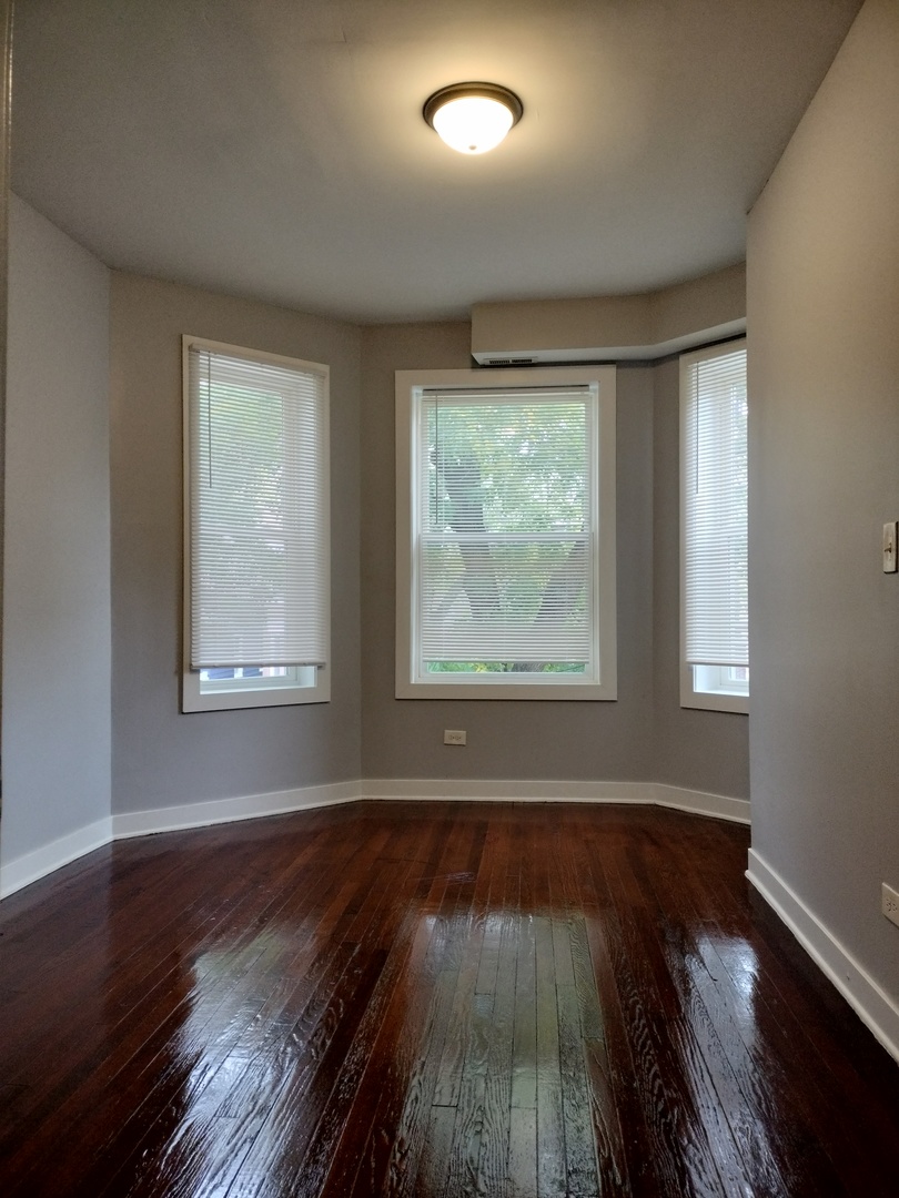 6603 South Bishop Street, Unit 66032 Chicago, IL 60636 - Photo 3 of 19 a view of an empty room with wooden floor and a window