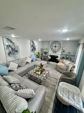 a living room with furniture and wooden floor