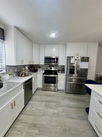 a kitchen with granite countertop a refrigerator stove and oven