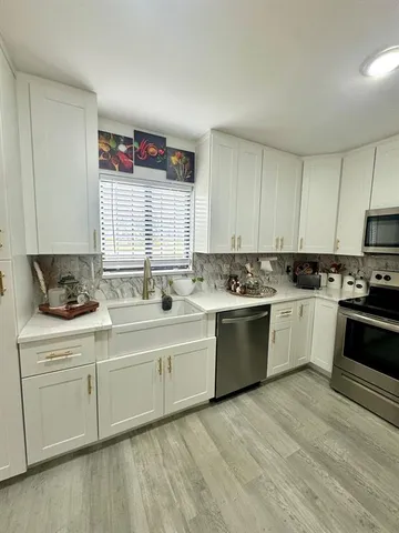 a kitchen with a white cabinets sink and white appliances