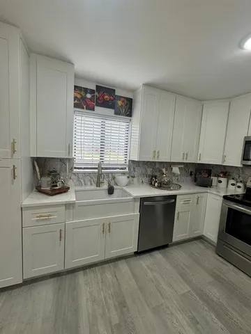 a kitchen with stainless steel appliances granite countertop a sink and cabinets
