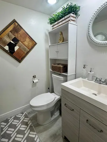 a bathroom with a toilet a sink and mirror