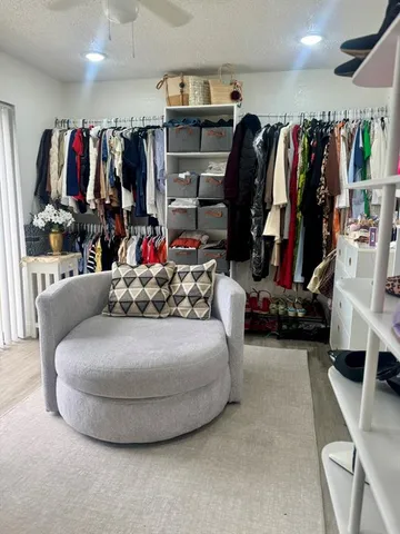 a view of walk in closet with clothes and shoes