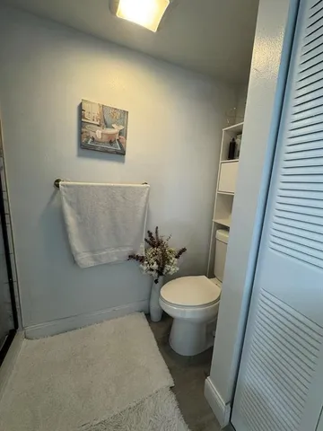 a white toilet sitting next to a white wall