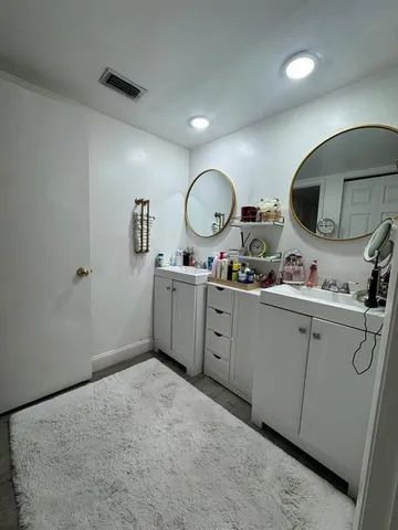 a spacious bathroom with a double vanity sink and a mirror