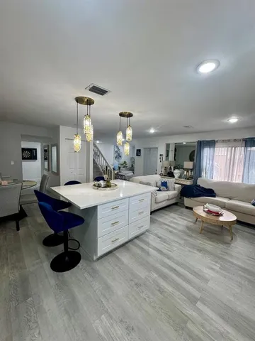a large living room with furniture a rug and white walls