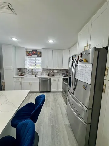 a kitchen with stainless steel appliances sink refrigerator and microwave
