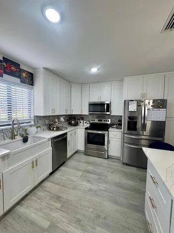 a kitchen with a sink stainless steel appliances and cabinets