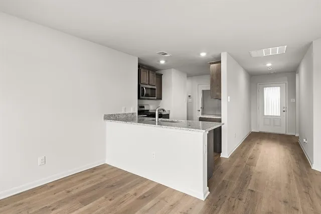 a kitchen with a sink and wooden floor