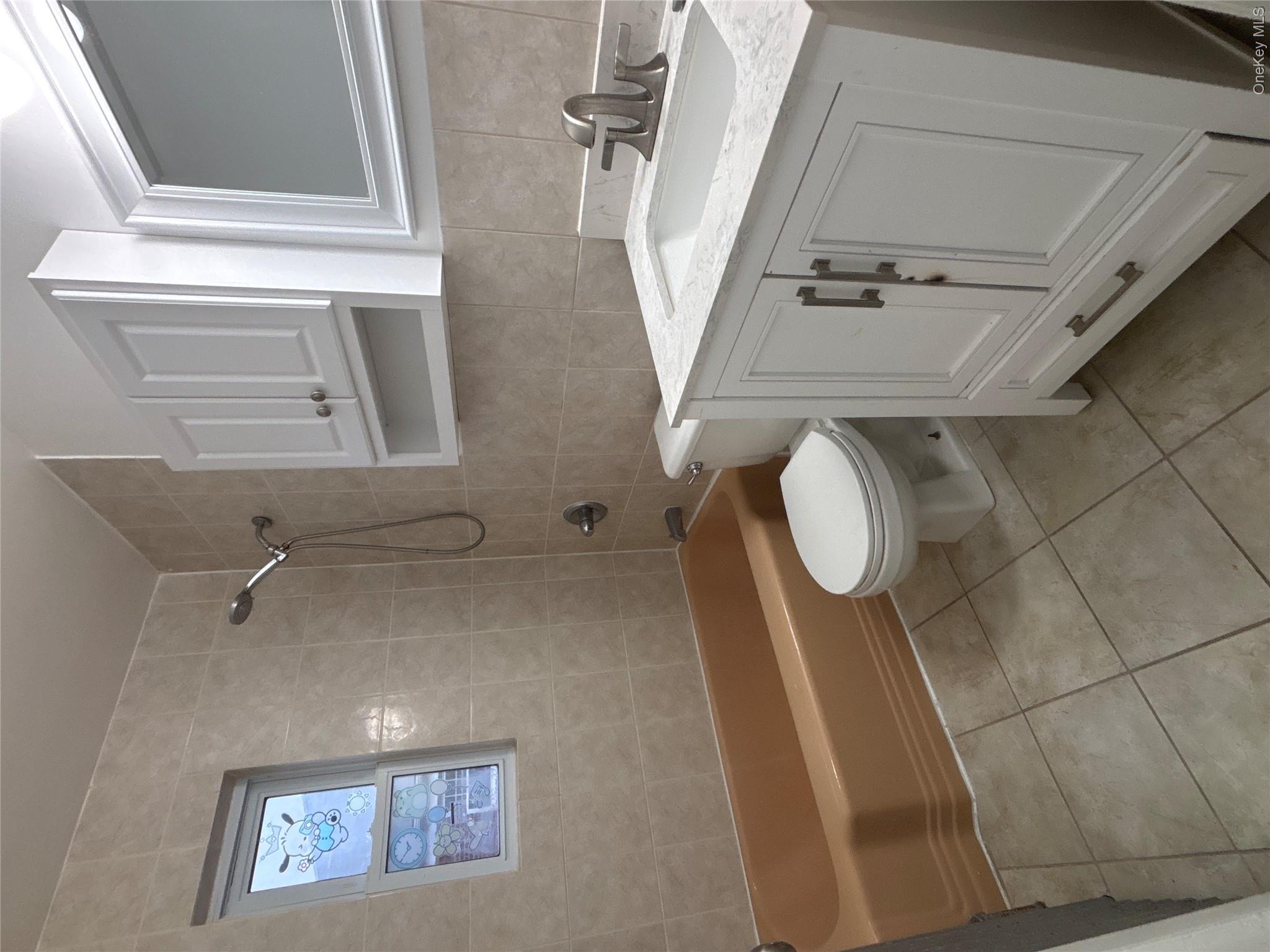 37 Spruce Street, Unit 3 Great Neck, NY 11021 - Photo 12 of 15 Full bath with vanity, bathtub / shower combination, tile walls, and light tile patterned flooring