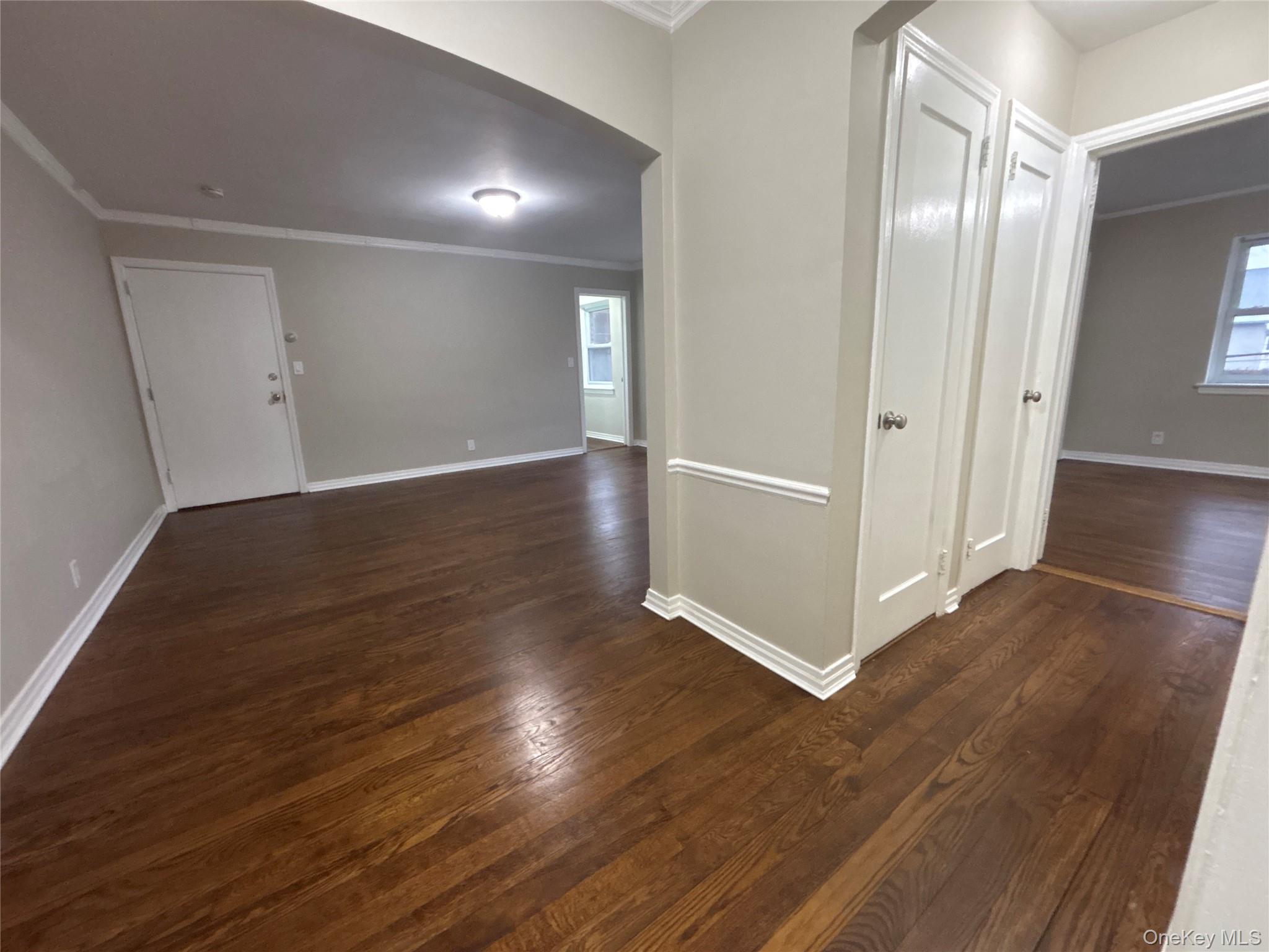 37 Spruce Street, Unit 3 Great Neck, NY 11021 - Photo 4 of 15 Corridor with ornamental molding, dark wood-style floors, arched walkways, and plenty of natural light