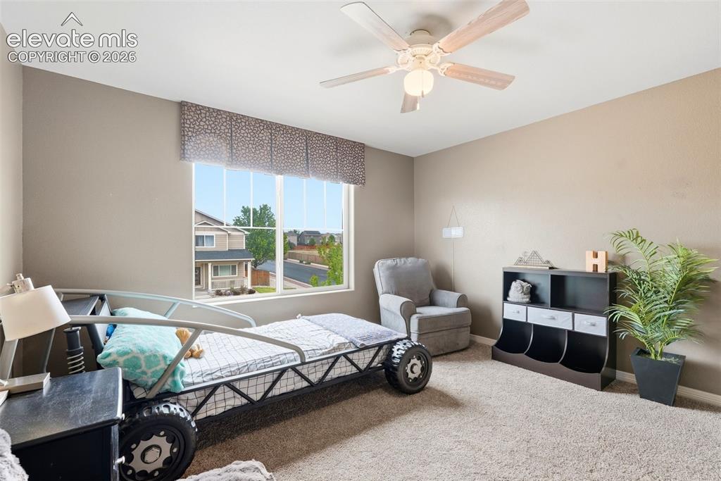 2264 Reed Grass Way Colorado Springs, CO 80915 - Photo 26 of 50 a spacious bedroom with a bed and a chandelier