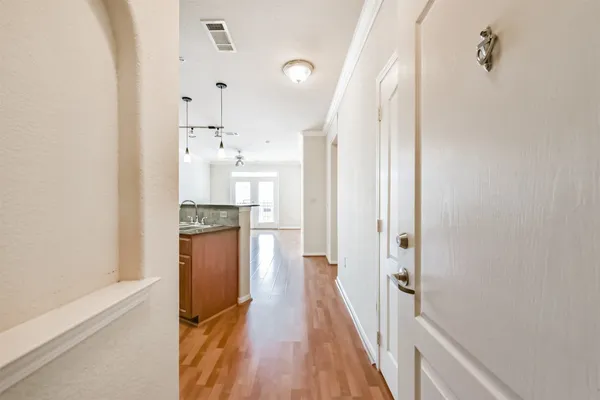 a view of an empty room with a window and wooden floor