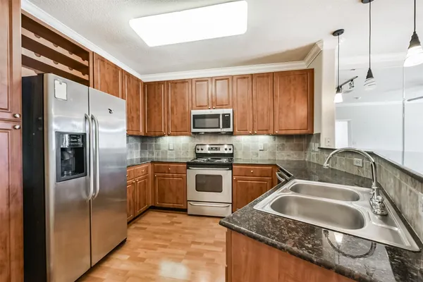 a kitchen with stainless steel appliances granite countertop a sink stove and microwave