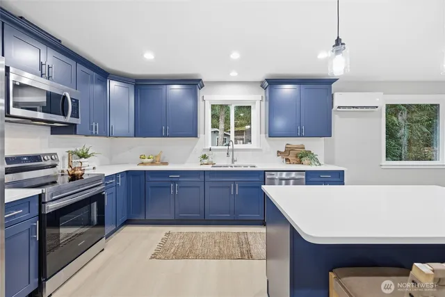 a kitchen with a sink a stove a microwave and wooden cabinets