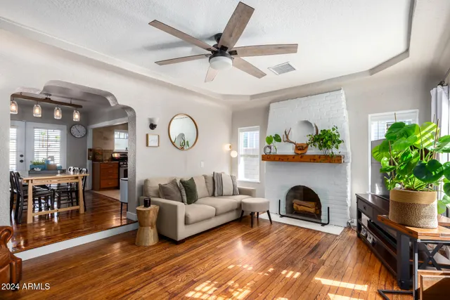 a living room with furniture a clock and a fireplace