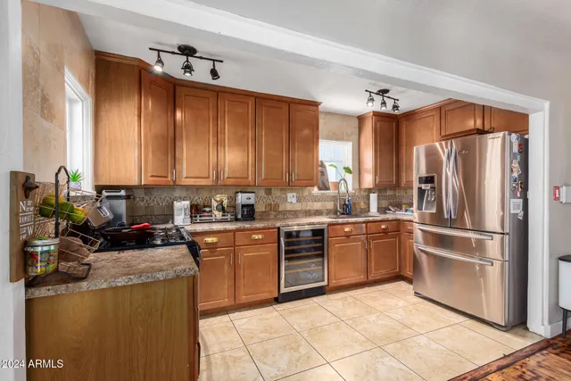 a kitchen with stainless steel appliances granite countertop a refrigerator and a stove top oven