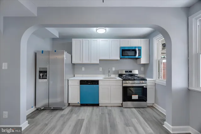 a kitchen with stainless steel appliances granite countertop a stove a refrigerator and a microwave