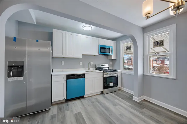 a kitchen with stainless steel appliances granite countertop a refrigerator and a stove top oven