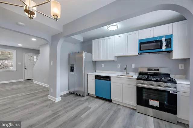 a kitchen with stainless steel appliances a stove a sink and a microwave