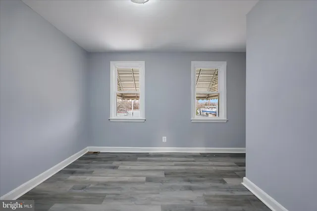 a view of a room with wooden floor and windows