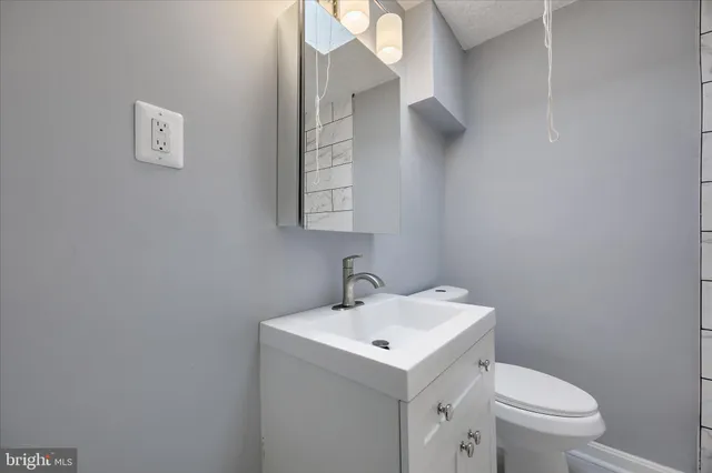 a bathroom with a sink a toilet and mirror
