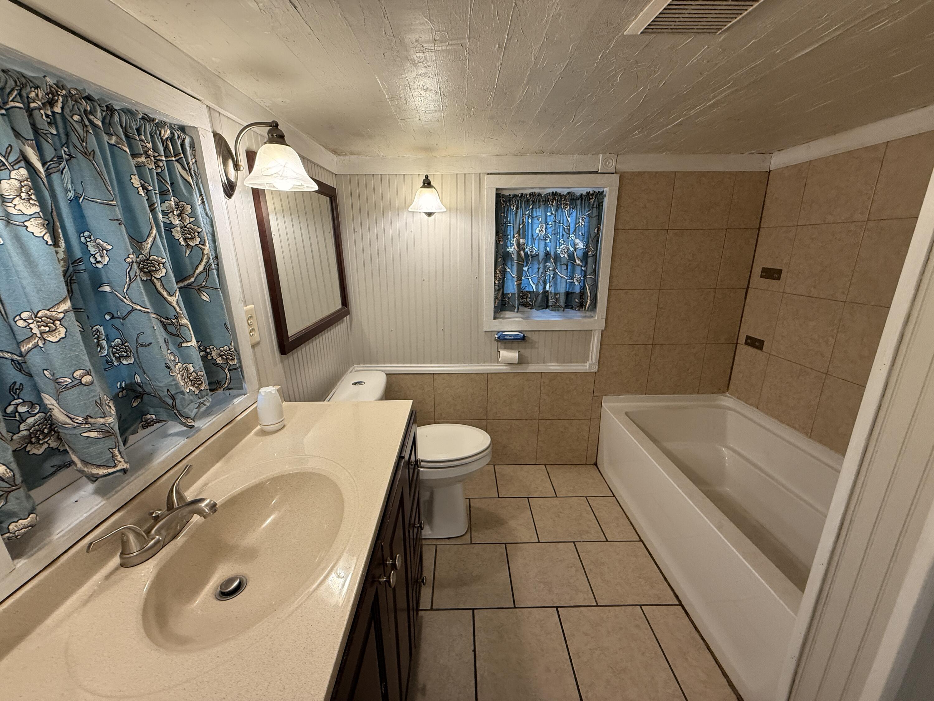 299 Carl Place Crestview, FL 32539 - Photo 16 of 37 a bathroom with a sink a toilet a mirror a vanity and bathtub
