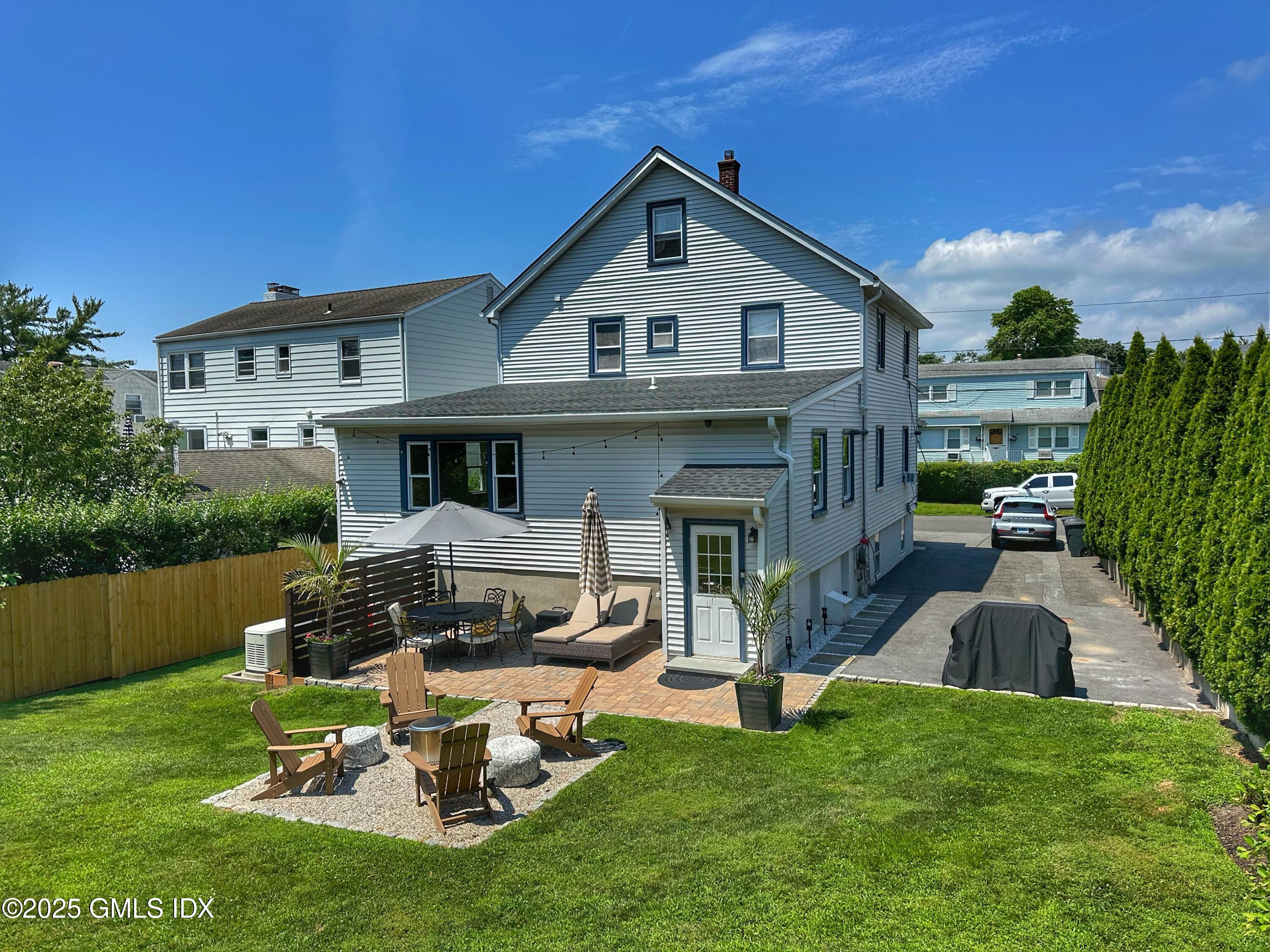 37 Gerry Street, Unit 2 Greenwich, CT 06830 - Photo 12 of 13 a front view of a house with a yard table and chairs