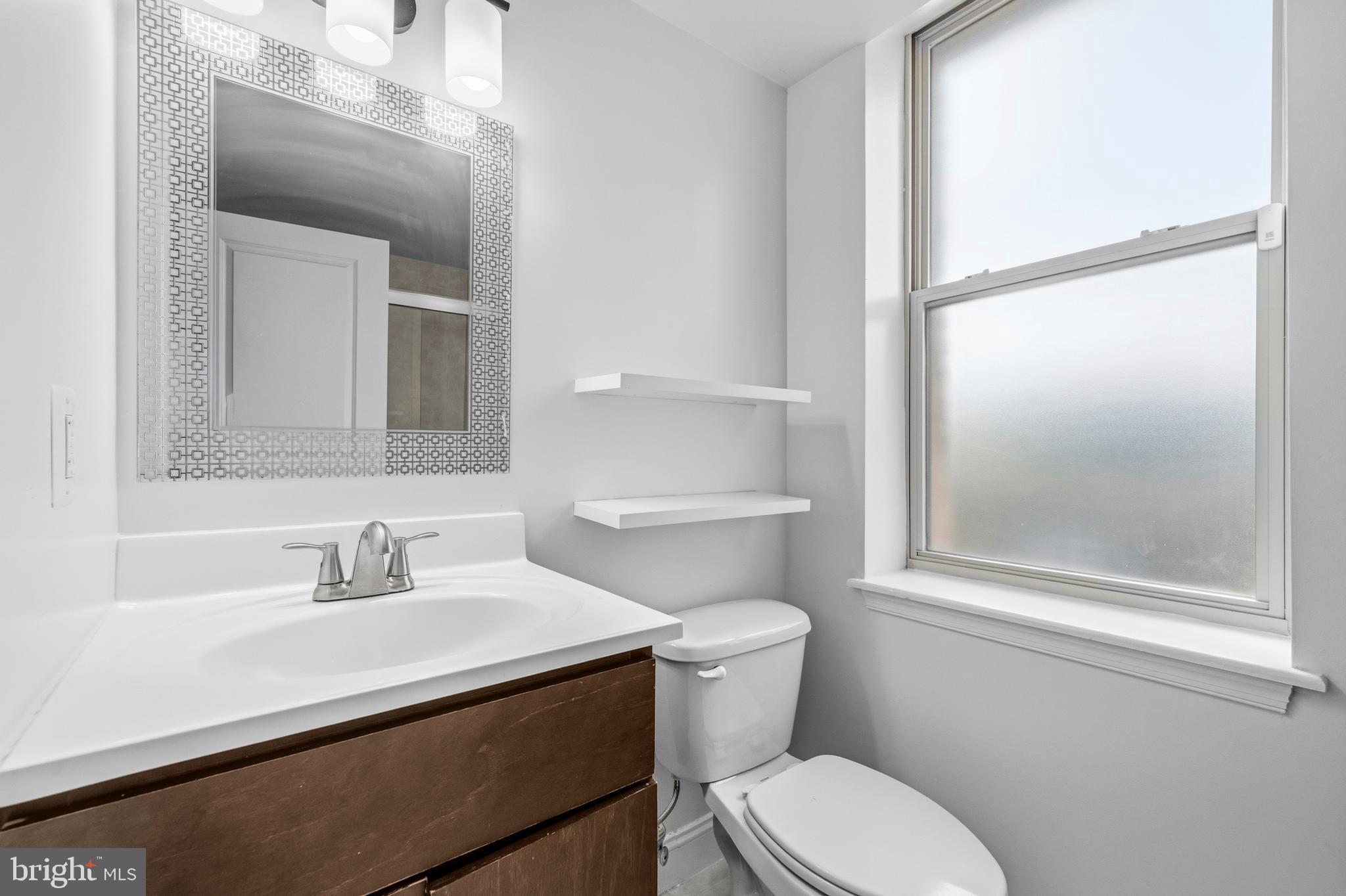 1831 2nd Street Northeast, Unit 207 Washington, DC 20002 - Photo 14 of 33 a bathroom with a sink a mirror and a toilet