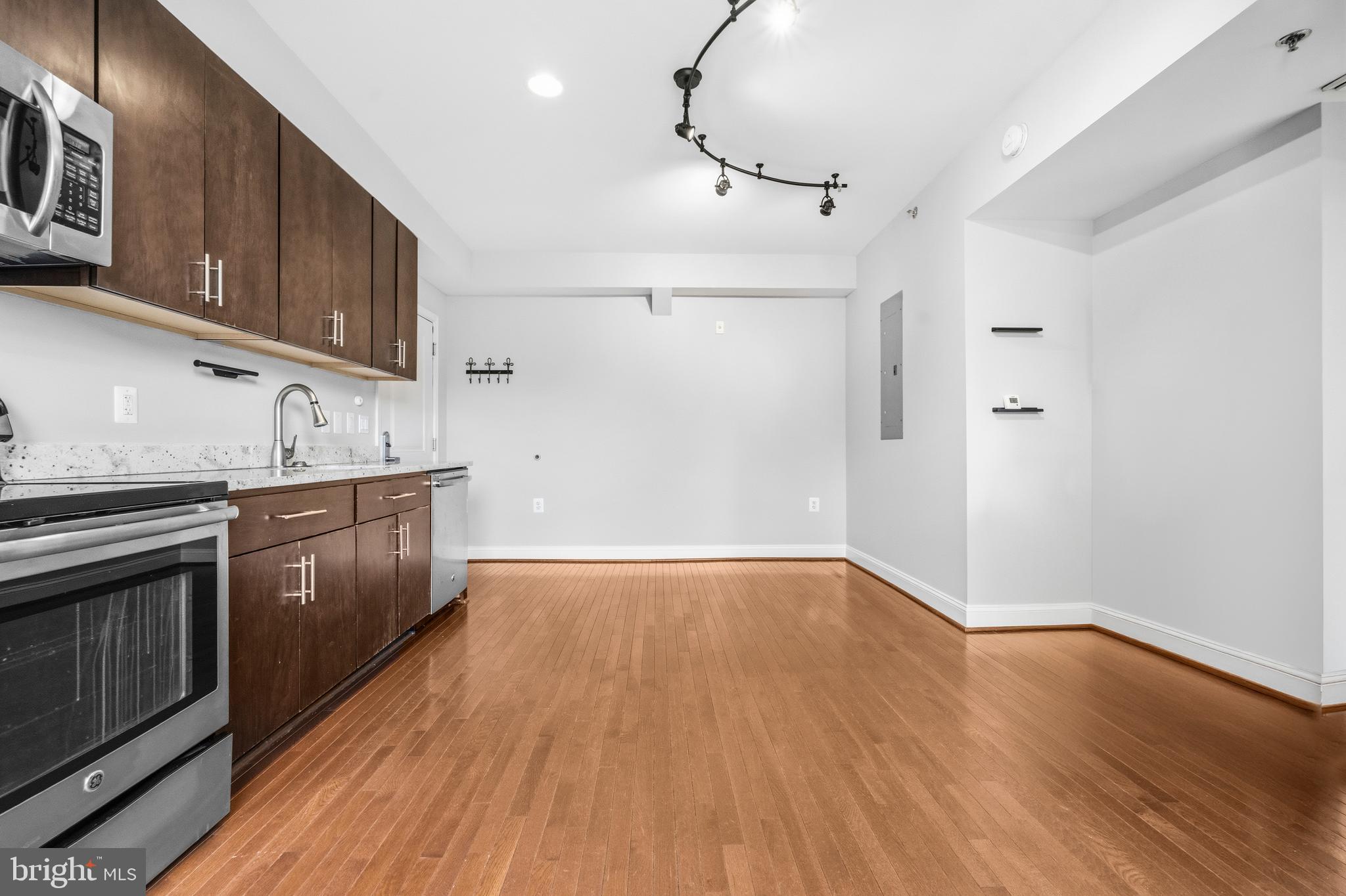 1831 2nd Street Northeast, Unit 207 Washington, DC 20002 - Photo 6 of 33 a kitchen with stainless steel appliances granite countertop a sink a stove a refrigerator and cabinets with wooden floor