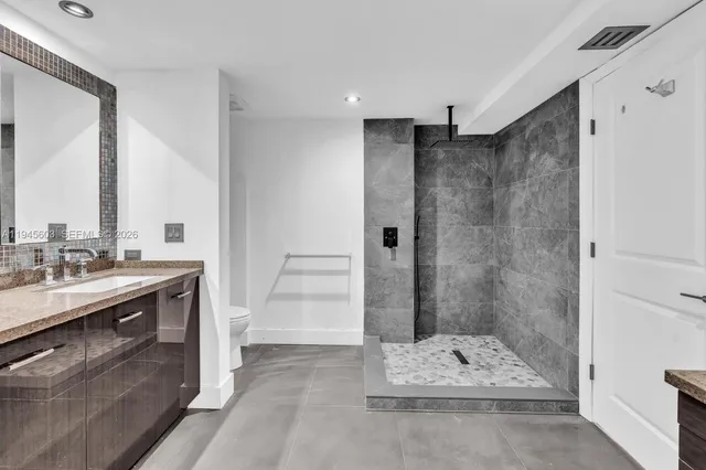 a bathroom with a sink mirror and shower