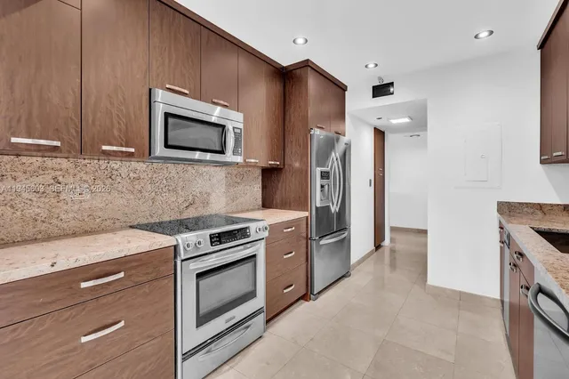 a kitchen with stainless steel appliances granite countertop a stove and a refrigerator