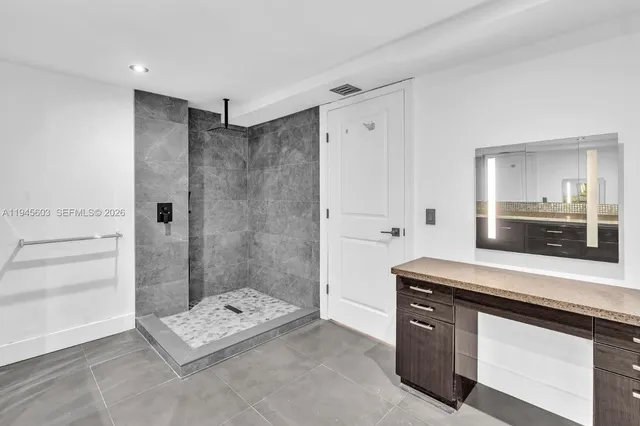 a spacious bathroom with a shower sink and mirror