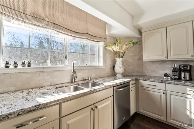 a kitchen with stainless steel appliances granite countertop a sink a stove and cabinets