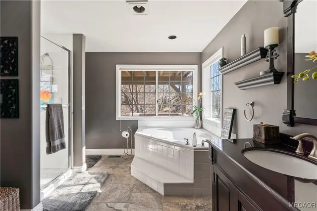 a bathroom with a granite countertop sink and a mirror