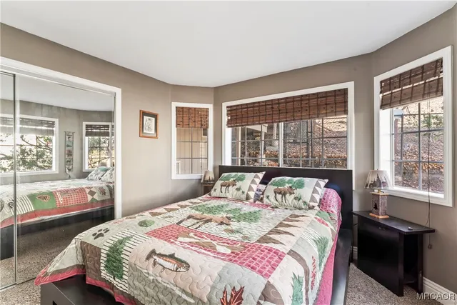 a bedroom with a bed and a large window