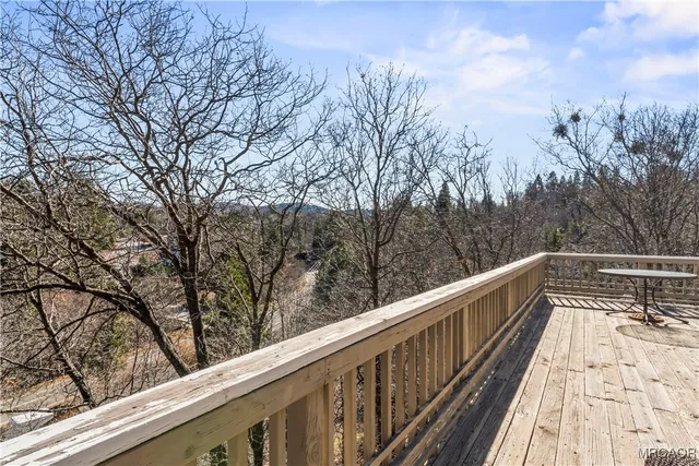 a view of trees and deck in the balcony