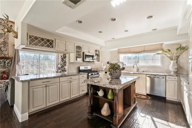 a kitchen with stainless steel appliances granite countertop a sink and cabinets